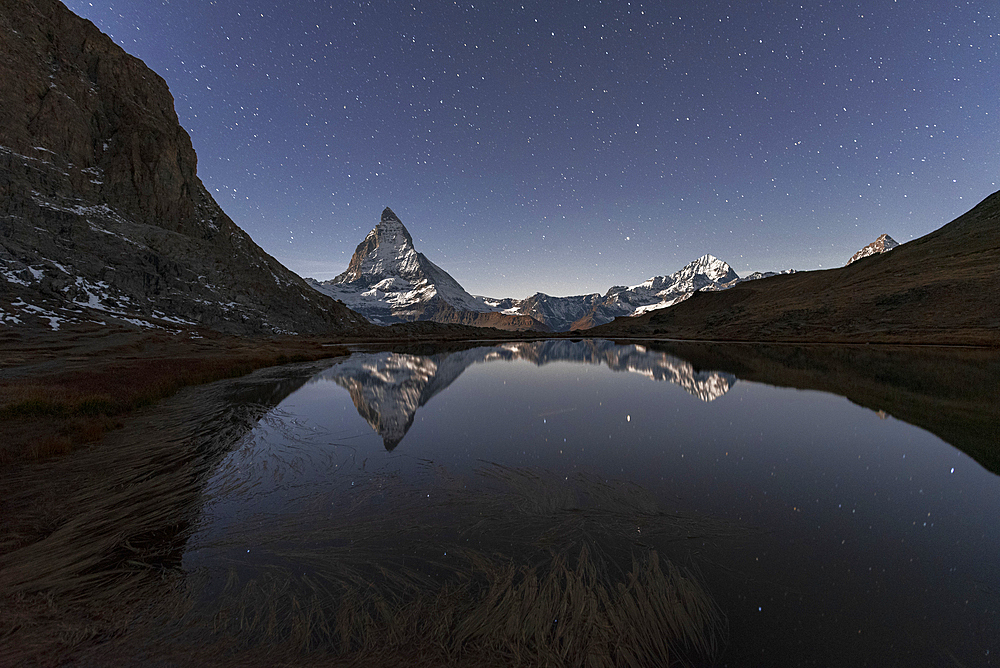 Matterhorn reflection in Riffelsee lake in a starry night, Gornergrat, Zermatt, canton of Valais, Swiss Alps, Switzerland, Europe