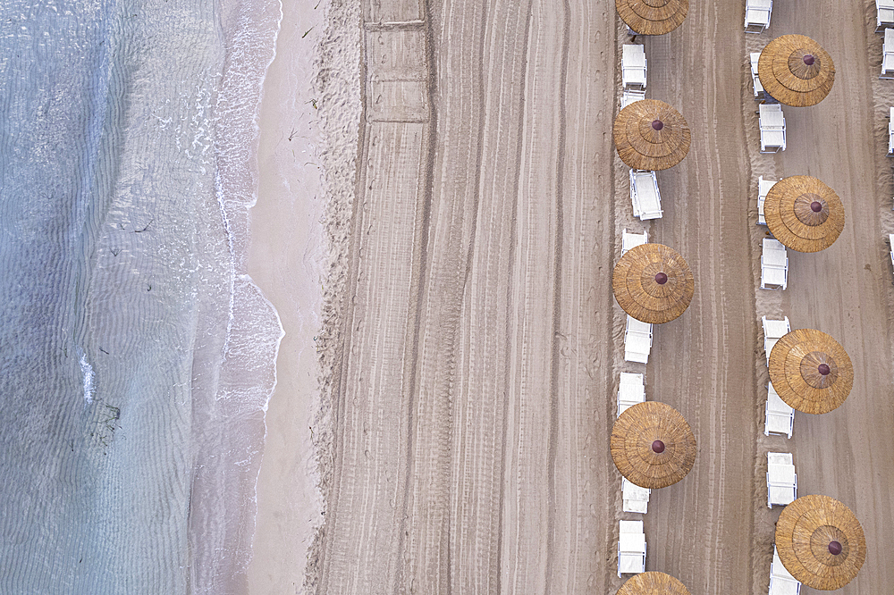 Drone view of beach straw umbrellas on an empty beach, Sicily, Mediterranean Sea, Italy, Europe