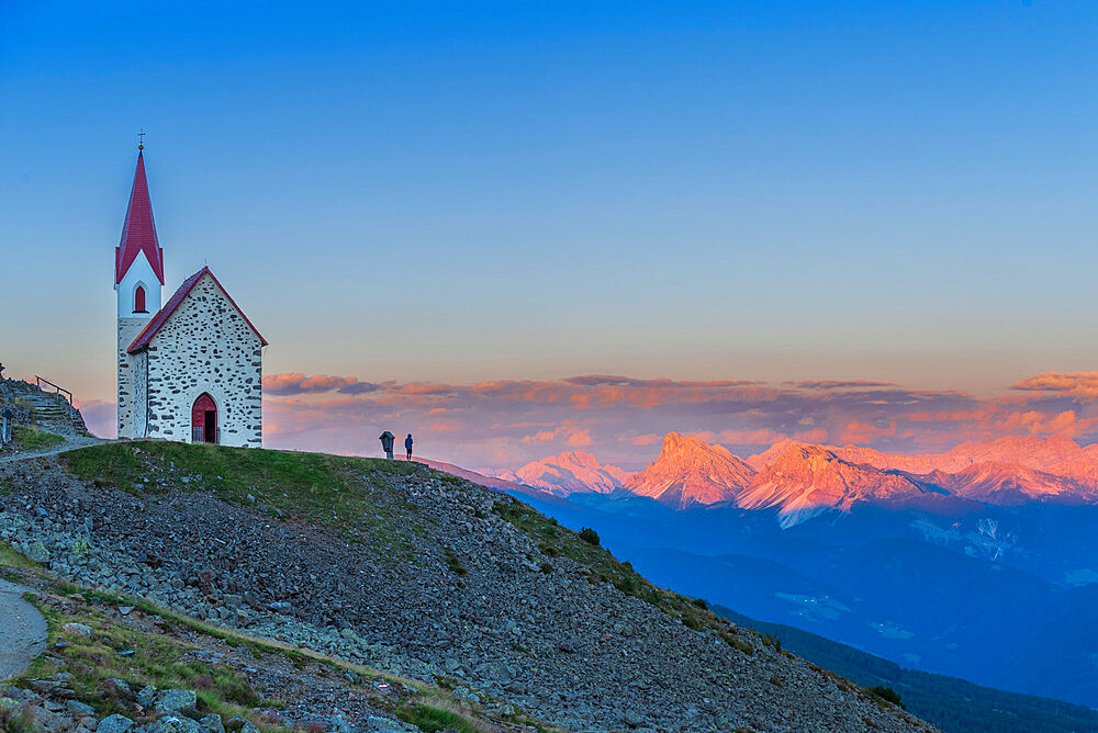 Man enjoys sunset over Dolomites at the pilgrimage church of Lazfons, Chiusa, Bolzano district, South Tyrol, Italy, Europe