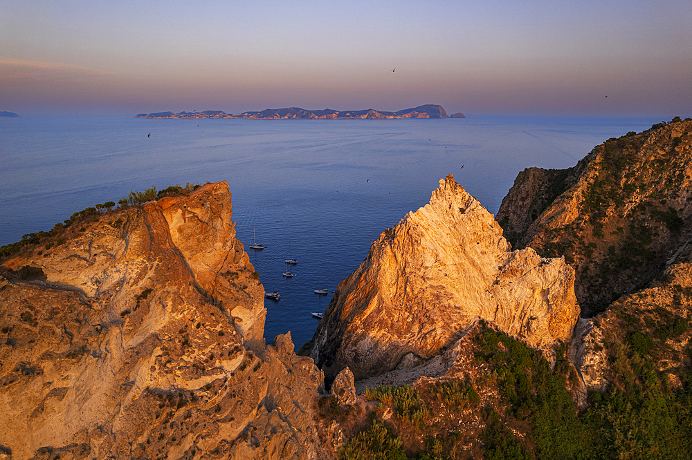 Aerial view of sharp cliffs of Palmarola island at sunset with the island of Ponza in the background, Ponza island, Tyrrhenian Sea, Pontine islands, Latina Province, Latium (Lazio), Italy, Europe