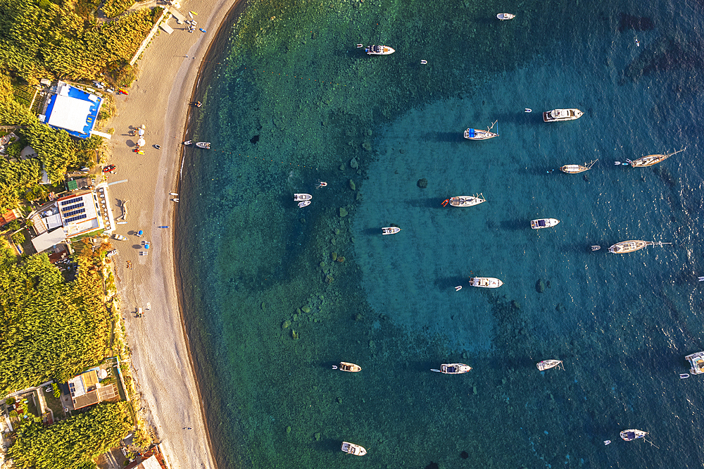 Aerial view of Palmarola bay with boats anchored in turquoise water at susnet, Palmarola island, Ponza municipality, Tyrrhenian sea, Pontine archipelago, Latina Province, Latium (Lazio), Italy, Europe