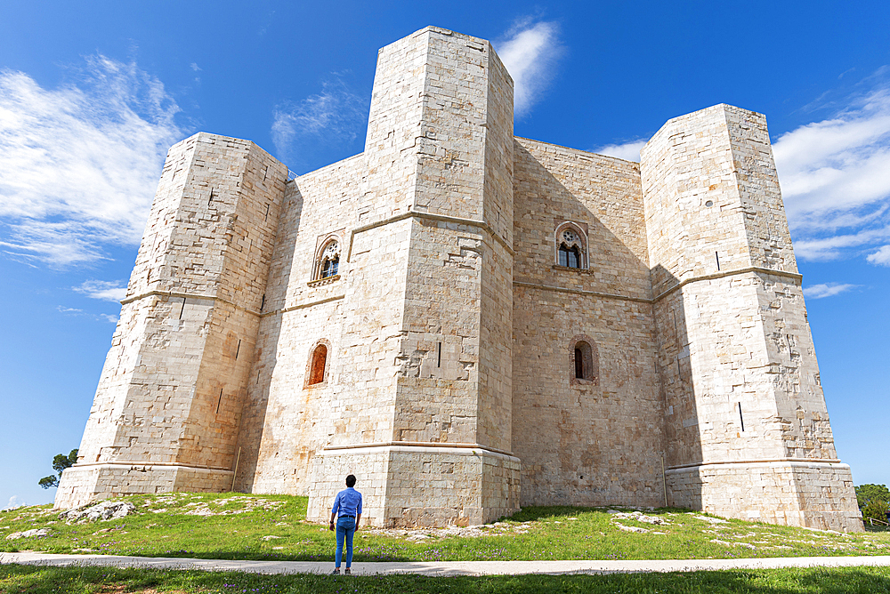 Man admires the octagonal castle of Castel del Monte in a clear sunny day, UNESCO World Heritage Site, Apulia, South of Italy, Italy, Europe