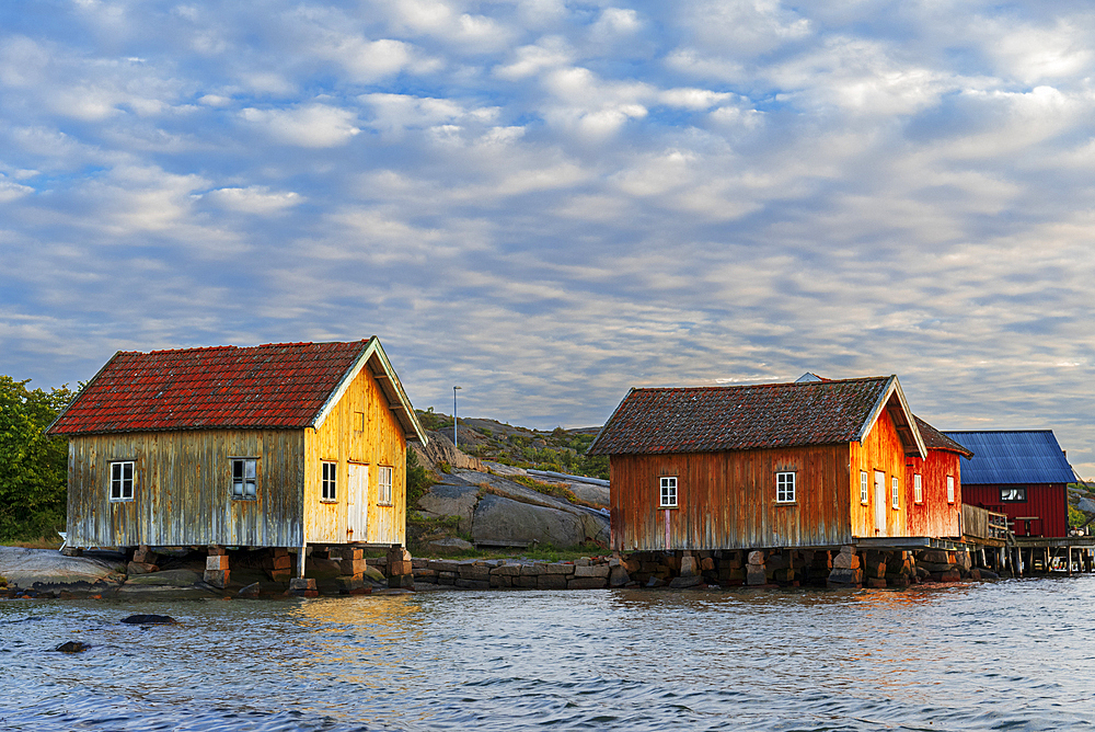 Traditional old rorbu cabins overlooking the ocean at sunset, Norway, Scandinavia, Europe