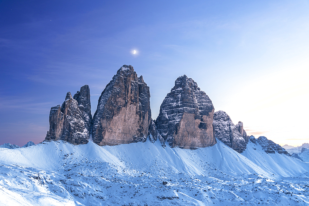 Moon above Tre Cime di Lavaredo at dusk, winter time, Tre Cime di Lavaredo (Lavaredo peaks) (Drei Zinnen), Sesto (Sexten), Dolomites, South Tyrol, Italy, Europe