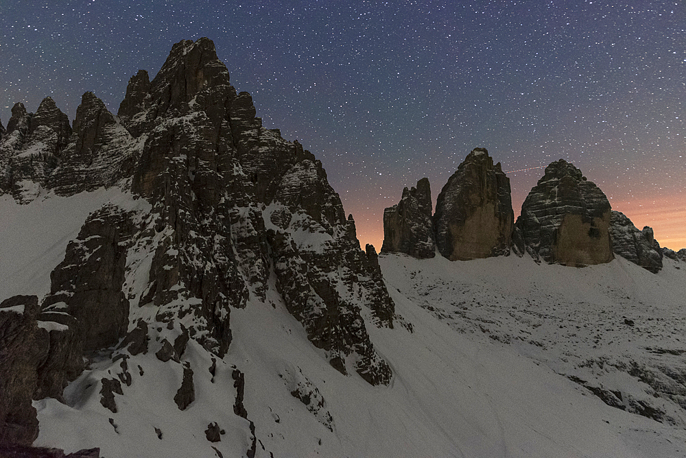 Starry night over Tre Cime di Lavaredo (Lavaredo peaks) and Paterno mountain, winter view, Sesto (Sexten), Dolomites, South Tyrol, Italy, Europe