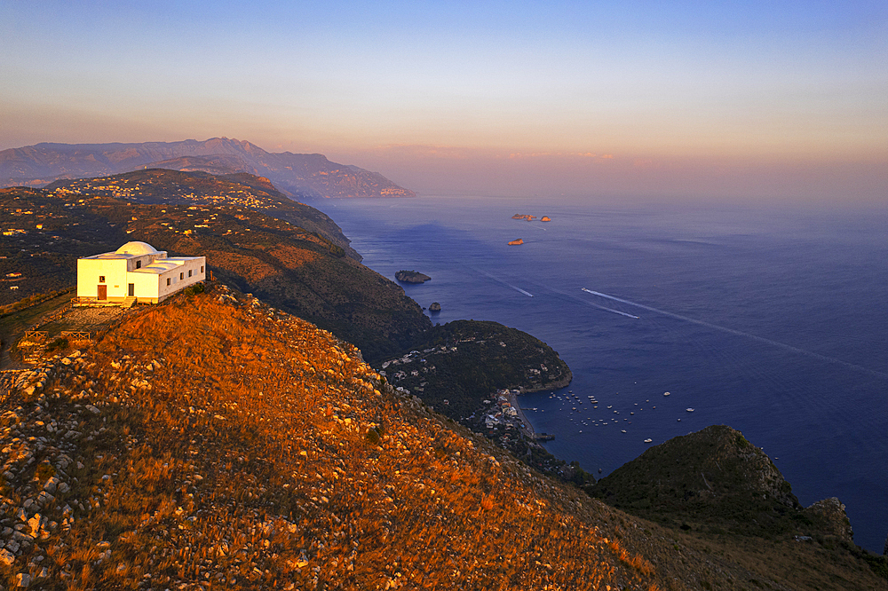 White church of San Costanzo on top of a mountain surrounding the Amalfi coast at sunset, Punta Campanella, Massa Lubrense, Naples province, Campania, Italy, Europe