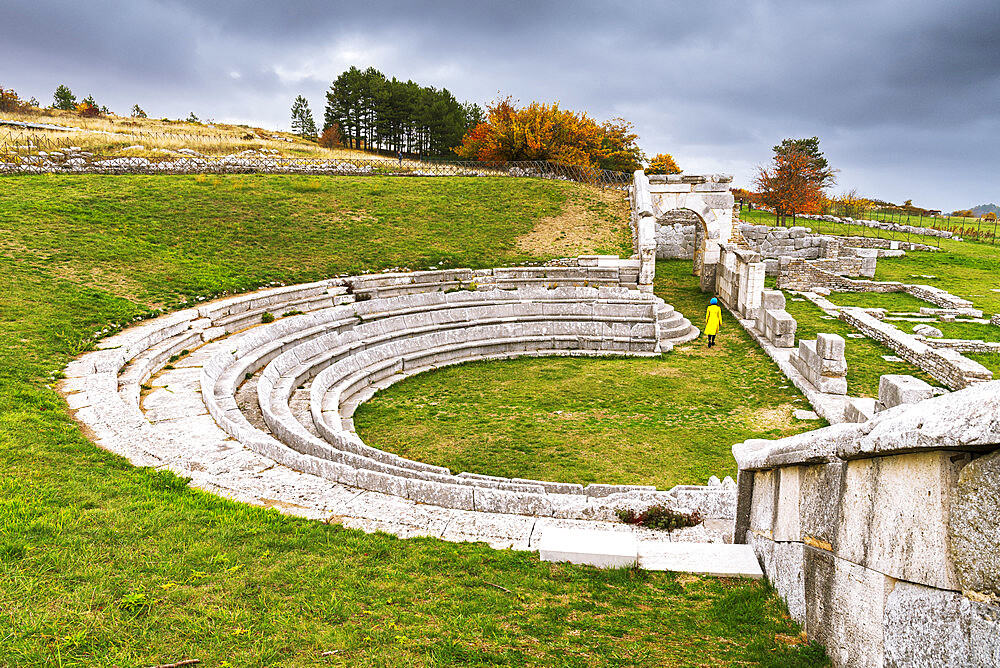 Woman enjoys the visit in the theatre of the Samnium archaeological site of Pietrabbondante, Isernia province, Molise, Italy, Europe