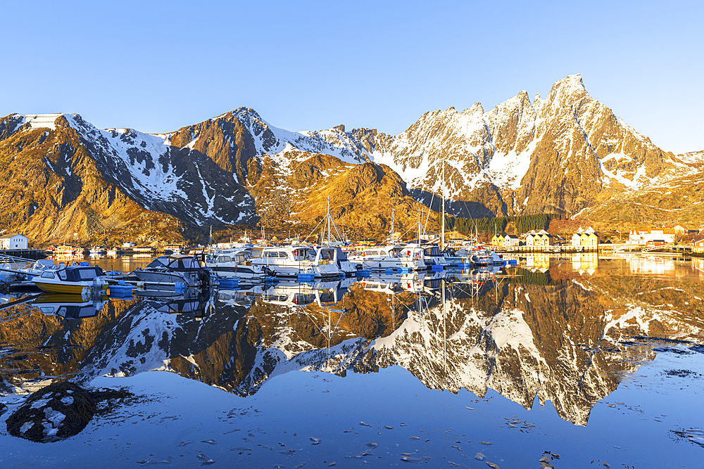 Morning view of the marina of Ballstad and reflection of mountains in the calm and frozen water, spring season, Ballstad, Vestvagoy, Lofoten Islands, Norway, Scandinavia, Europe