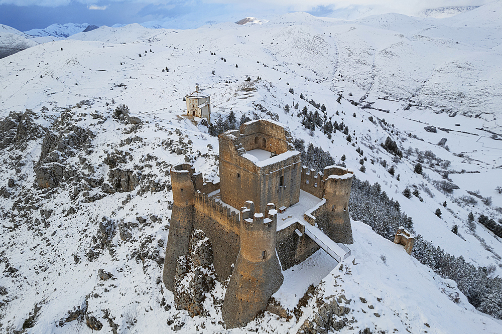 Close-up aerial view of the snow covered medieval castle of Rocca Calascio and the church of Santa Maria della Pieta� at dusk, Rocca Calascio, Gran Sasso e Monti della Laga National Park, Campo Imperatore, L'Aquila province, Abruzzo region, Italy, Europe