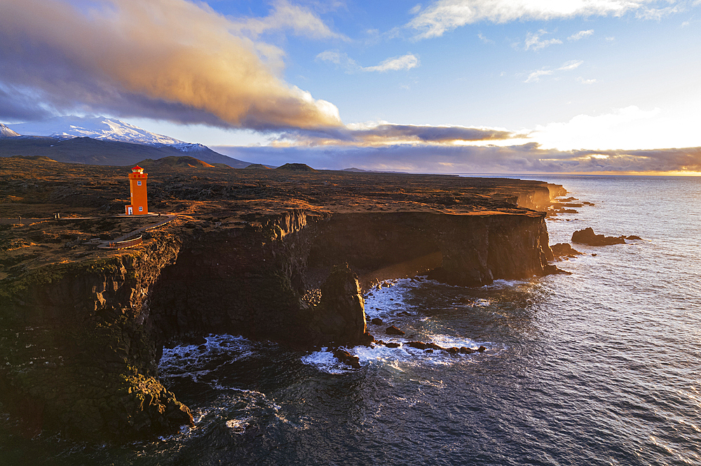 Aerial view of the orange Svortuloft lighthouse on top of the basalt cliffs at sunset, Snaefellsbaer, Snaefellsjokull National Park, Snaefellsens peninsula, Vesturland, West Iceland, Iceland, Polar Regions