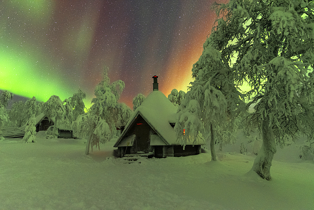 Huts in the snowy wood under the Northern Lights (Aurora Borealis), Pallas-Yllastunturi National Park, Muonio, Lapland, Finland, Europe