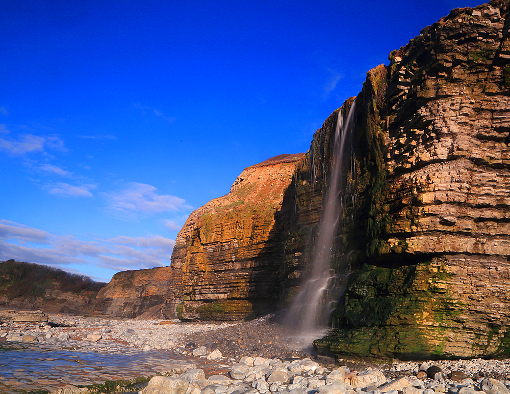 Waterfall at Cwm Bach, Traeth Bach Beach, near Southerndown, Glamorgan Heritage Coast, South Wales, United Kingdom, Europe