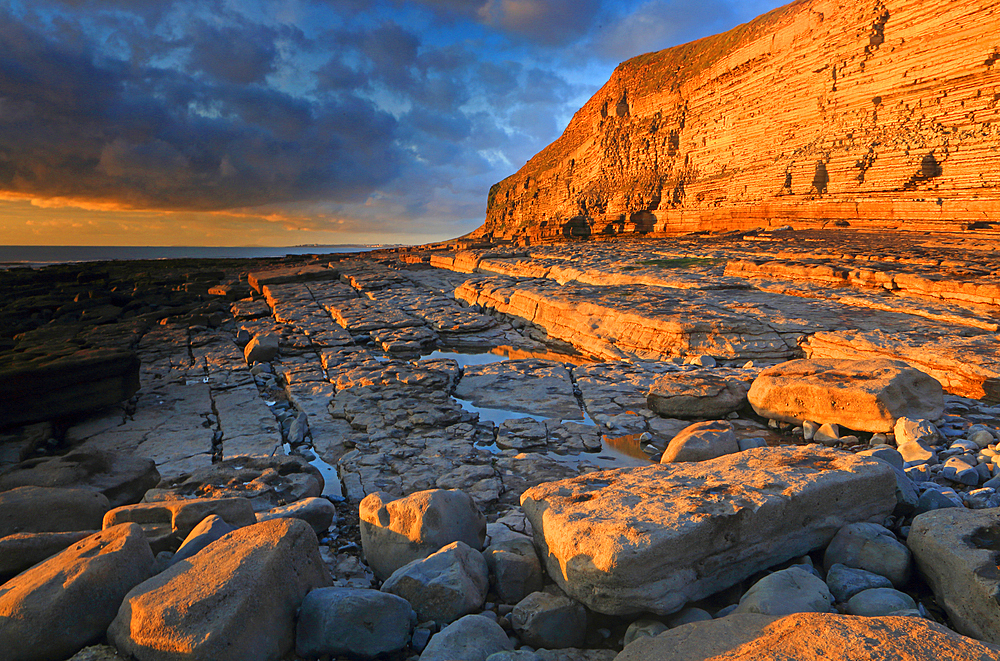 Golden evening light on the limestone cliffs, Dunraven Bay, Southerndown, Vale of Glamorgan, Wales, United Kingdom