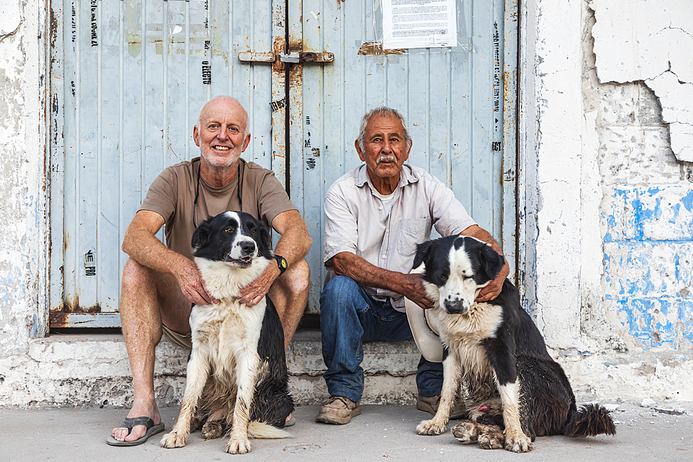 San Javier, Loreto, Baja California Sur, Mexico. November 16, 2021. Two men with dogs in San Javier.