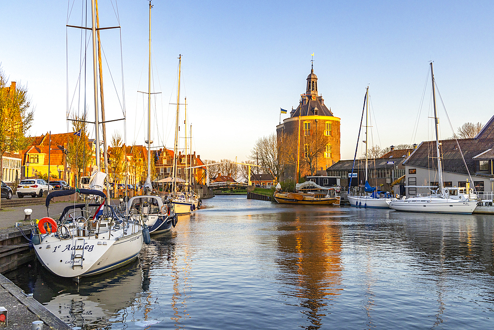 Europe, Netherlands, North Holland, Enkhuizen. April 24, 2022. Pleasure boats on a Dutch canal at sunset.