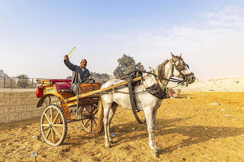 Giza, Cairo, Egypt. February 18, 2022. Horse cart and driver at the Great Pyramid complex in Giza.