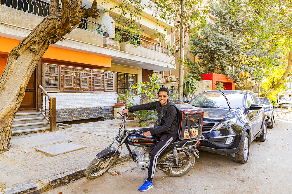 Cairo, Egypt. February 11, 2022. Food delivery driver on a motorcycle in Cairo.