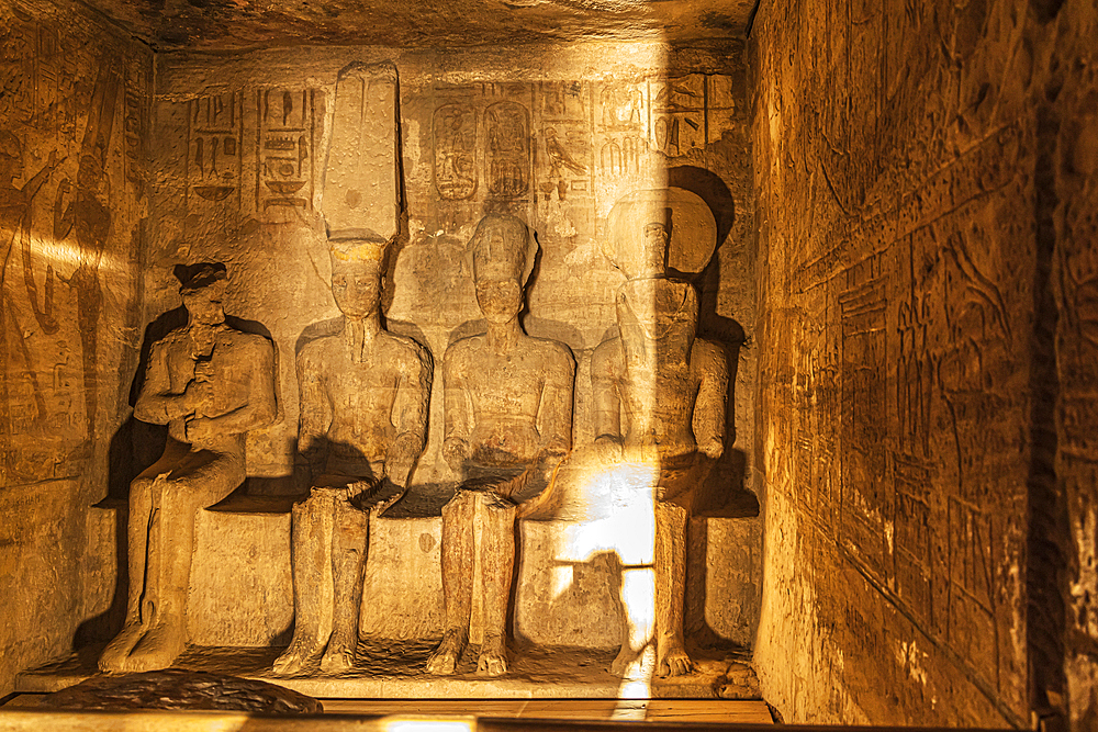 Abu Simbel, Aswan, Egypt. February 23, 2022. Sunrise light on statues of Ptah, Amun, Ramesses II, and Ra in the Holiest of Holies in the Great Temple of Ramesses II.