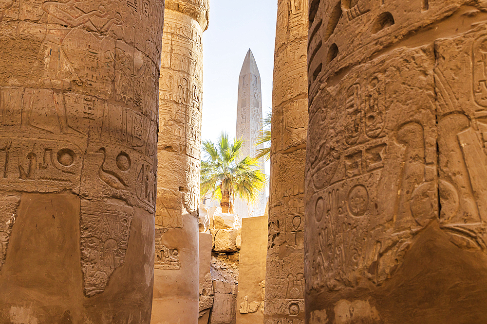 Karnak, Luxor, Egypt. Obelisk of Queen Hatshepsut through columns of the Great Hypostyle Hall at the Karnak Temple complex in Luxor.