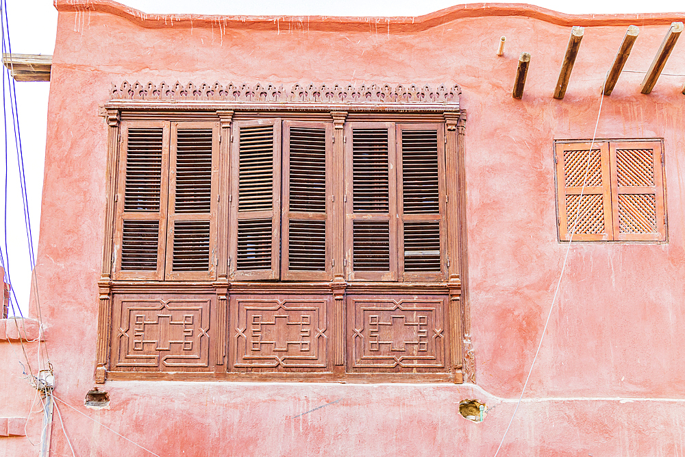 Faiyum, Egypt. Shuttered window on a pink stucco building in Faiyum.