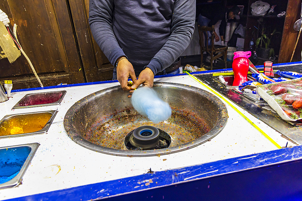 Cairo, Egypt. Man making spun sugar, cotton candy, at a shop on El Moez street in Old Cairo.