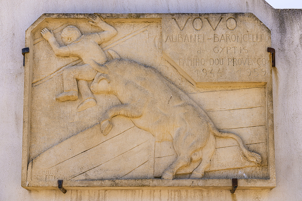 Saintes-Maries-de-la-Mer, Bouches-du-Rhone, Provence-Alpes-Cote d'Azur, France. July 3, 2022. Historic wall plaque of a bull chasing a man in Saintes-Maries-de-la-Mer.