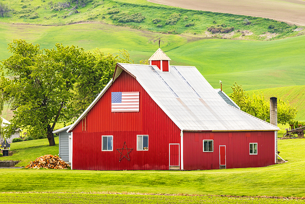 Garfield, Washington, USA. May 24, 2021. A red barn with an American flag in the Palouse hills. Editorial Use Only