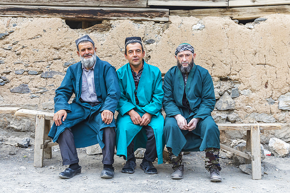 Haft Kul, Sughd Province, Tajikistan. August 17, 2021. Three men in long coats in a mountain village. Editorial Use Only