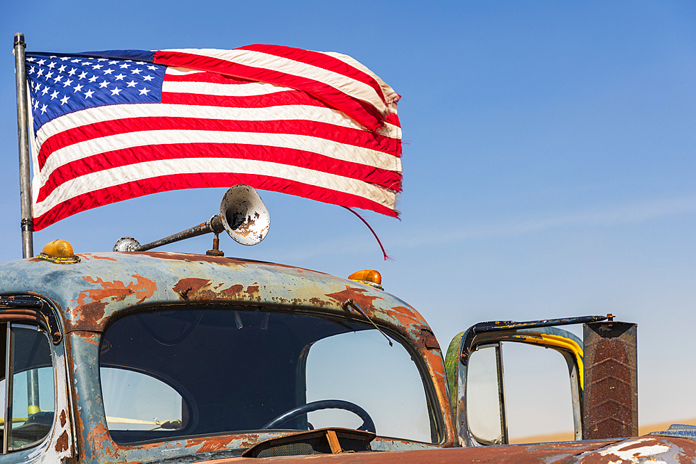 USA, Washington State, Whitman County. Palouse. American flag flying on an old rusted truck.