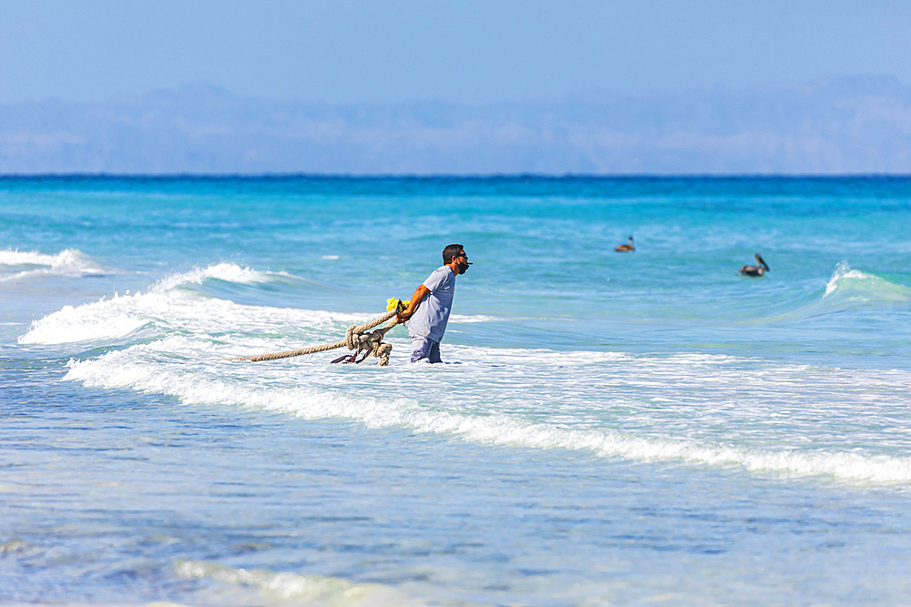 Playa El Tecolote, La Paz, Baja California Sur, Mexico. November 12, 2021. Fisherman pulling a a rope at Tecolote Beach.