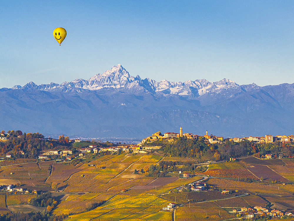 Hot air balloon flight over La Morra village with a Monviso Mountain in the background, on an autumn day, Cuneo province, Piedmont, Italy, Europe