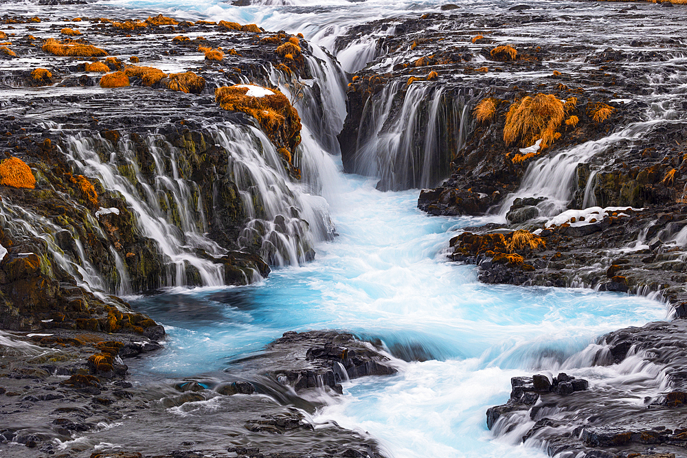 The incredibly colorful details of the famous Bruarfoss waterfall, with its turquoise water and golden grass, taken on a cold winter day, Iceland, Polar Regions