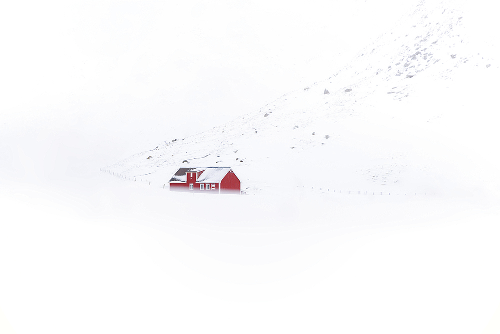 A red rorbu in the snow at Skagsanden beach, Flakstad, Flakstadoya, Nordland, Lofoten, Norway, Europe