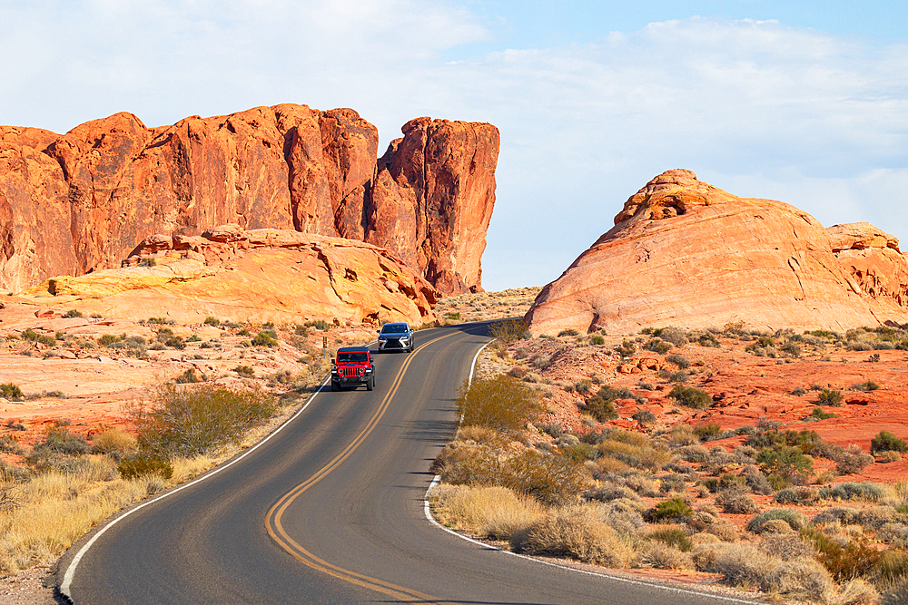 two cars drive along the scenics road in Valley of Fire State Park during a sunny summer day