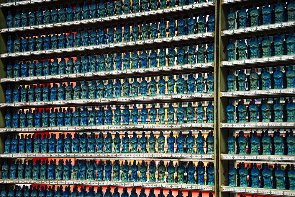 Close-up of small, blue Buddha statues neatly arranged on shelves, symbolizing serenity and devotion at Sanzen-in Temple, Kyoto.