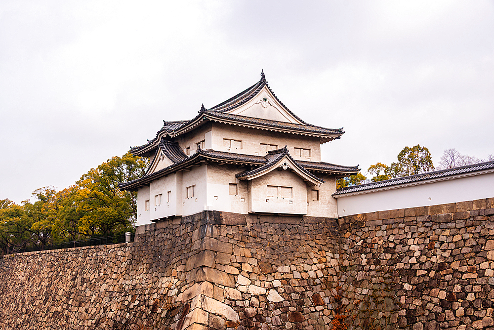 Osaka Castle in Japan. Overlooking the stone moat at Rokuban-yagura Turret on the outer walls framed by autumnal foliage