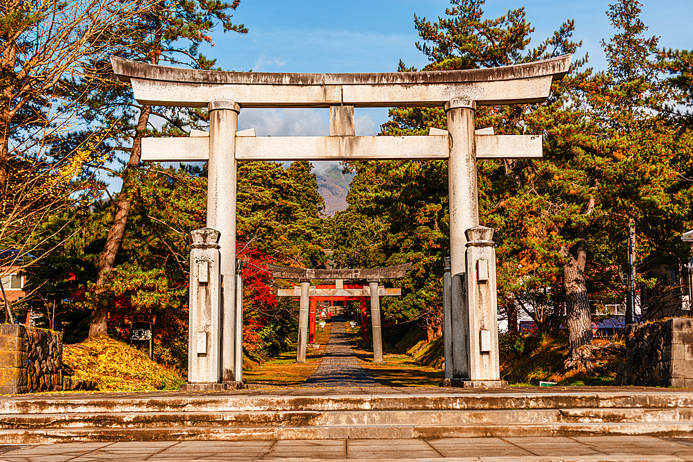 Big stone torii gate framing more distant gates on the foot of mount Iwaki. Iwakiyama-jinja Shrine Mt Iwaki Shrine in Hirosaki, Japan