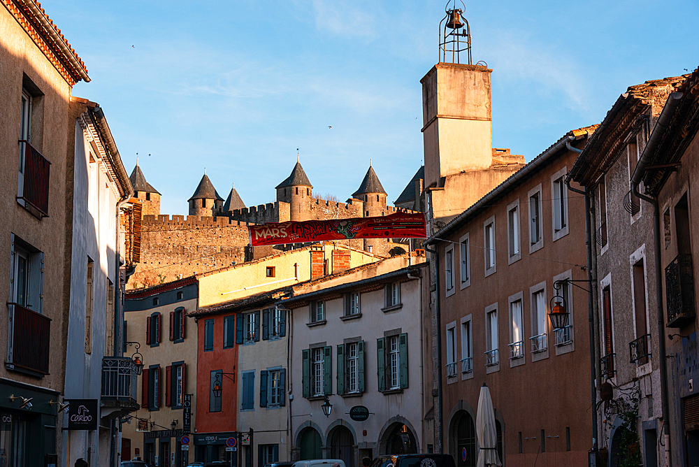 Old town in Rue Trivalle looking along the street with the castle in the background. Evening atmosphere in Carcassonne, Languedoc-Roussillon, France
