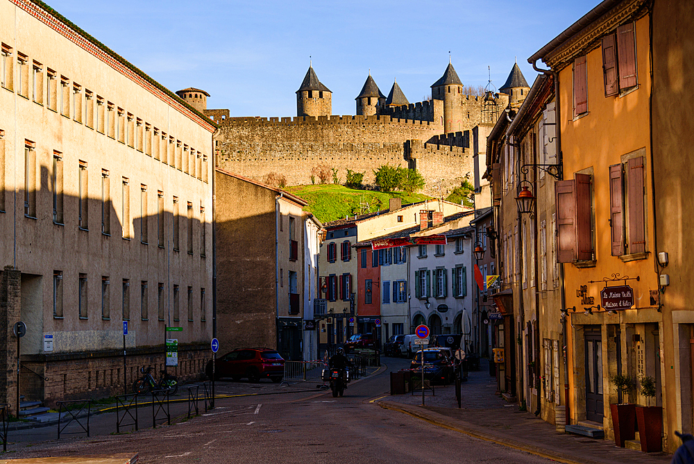 Old town in Rue Trivalle looking along the street with the castle in the background. Evening atmosphere in Carcassonne, Languedoc-Roussillon, France