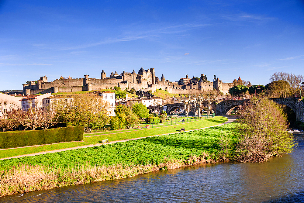 Medieval castle of Carcassonne, Languedoc-Roussillon, France. Lush green riverside bank of river Aude