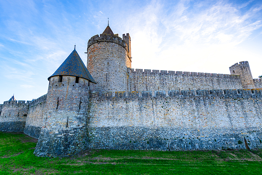 Medieval castle of Carcassonne, Languedoc-Roussillon, France. Lush green fields in front of the castle walls