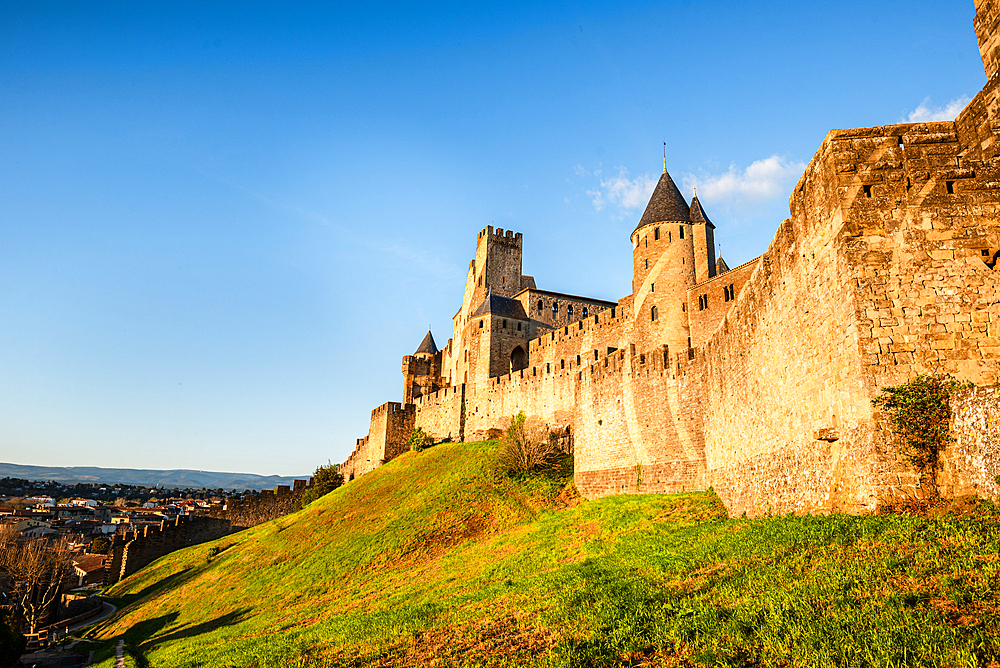 Green hilly slope and the stone fortification of the Medieval castle of Carcassonne, Languedoc-Roussillon, France