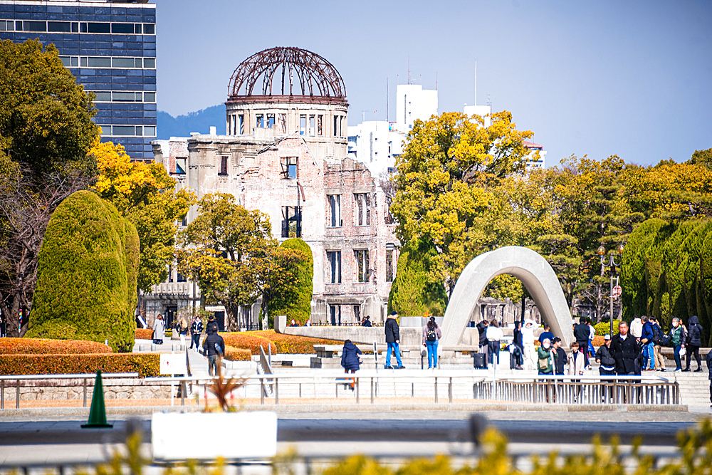 View of the Hiroshima Peace Memorial Cenotaph and Atomic Bomb Dome Surrounded by Visitors in Peace Memorial Park, Hiroshima, Japan