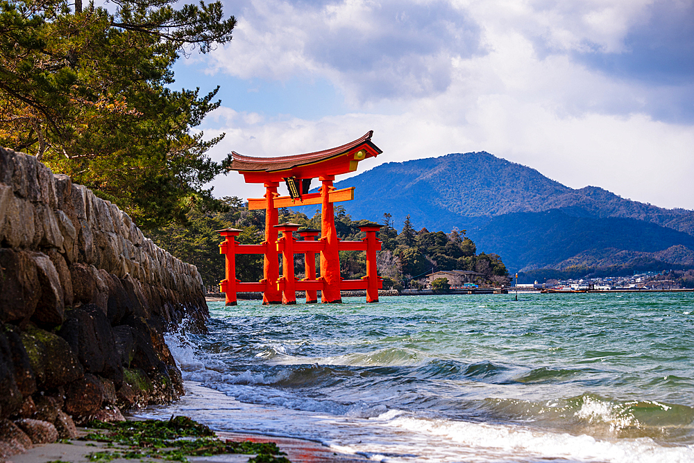 Scenic View of the Floating Torii Gate of Itsukushima Shrine from a Rocky Shoreline on Miyajima Island, Japan