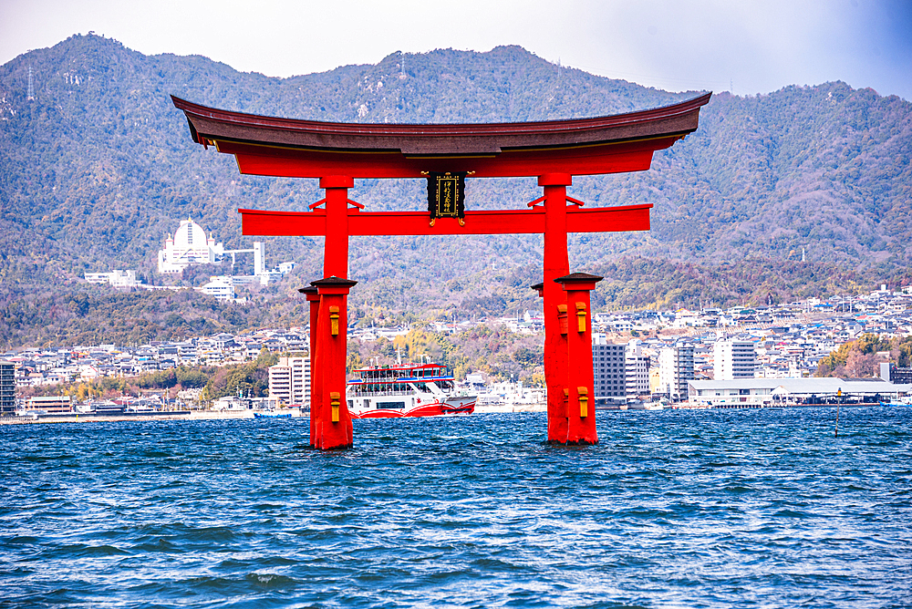 Close-Up of the Majestic Floating Torii Gate of Itsukushima Shrine with Cityscape Background on Miyajima Island, Japan