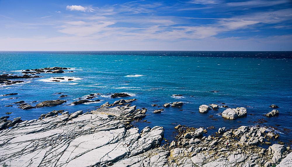 Rocky Shoreline and Vibrant Blue Ocean Waters Stretching Into the Horizon at Kaikoura Peninsula, New Zealand
