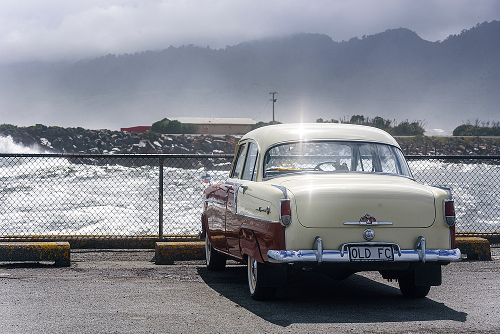 Classic Cream and Red Vintage Car Parked by the Waterfront on a Rainy Day in Hokitika, New Zealand
