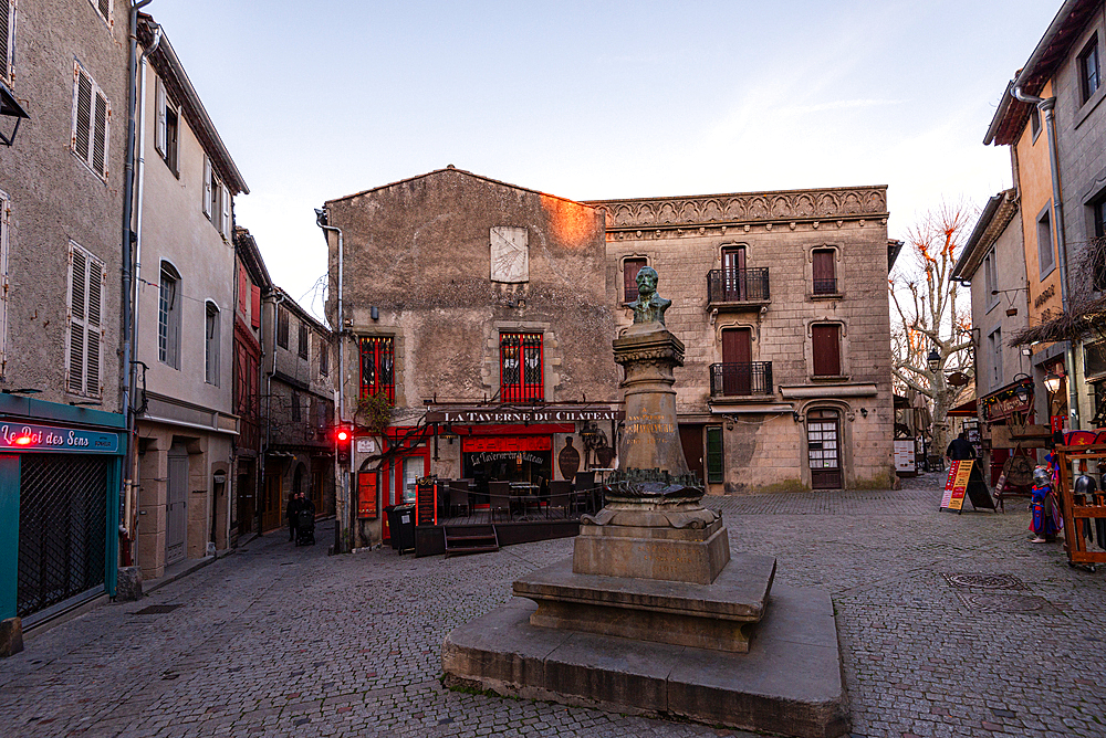 Historic Place Carnot at twilight with Neptune Fountain and surrounding shops in La Bastide Saint-Louis, Carcassonne, France