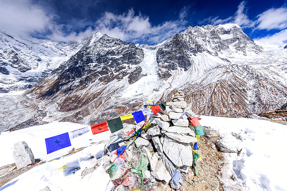 Stone Cairn Decorated with Prayer Flags on the Summit of Kyanjin Ri with Langtang Lirung Rising Above the Snowy Valley