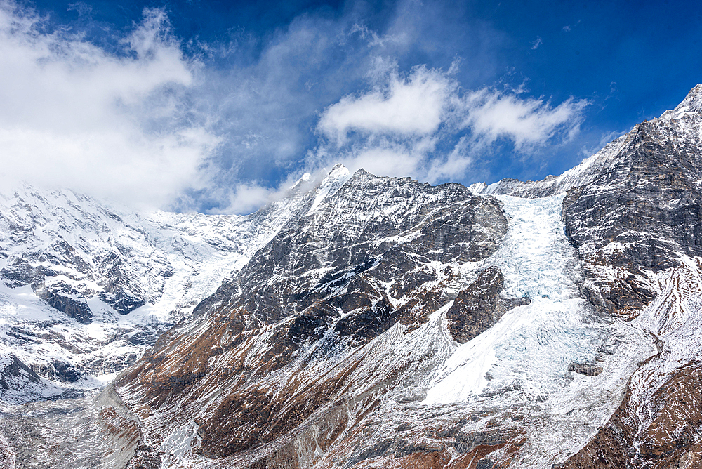 Massive glacier flowing down from Langtang Lirung under dramatic skies, viewed from high ridge in Langtang National Park, Nepal